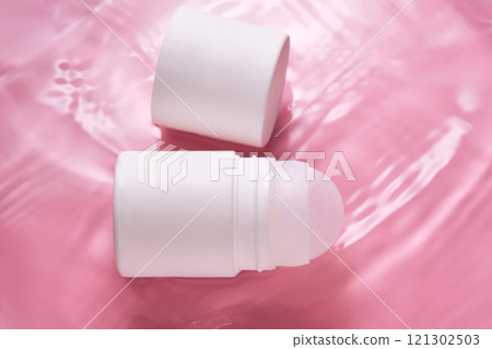 Roll-on deodorant on a pink background in water. Roll-on deodorant on a pink background in water. 121302503
