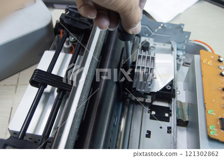 Top view of technician inspecting and repairing printer. Top view of technician inspecting and repairing printer. 121302862