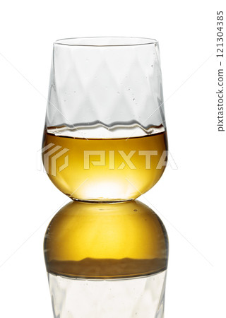 Whiskey in a glass on a white background. Whiskey in a glass on a white background. 121304385