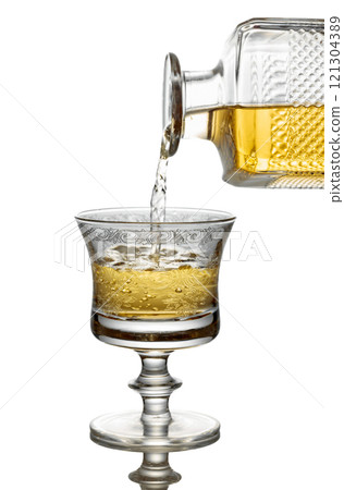 Gold liquor pouring into a glass on a white background. 121304389