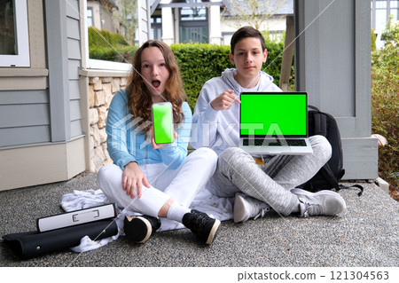 Cropped image of school kids preteen boys and girls elementary middle pupils sitting on the stairs and using digital devices wireless gadgets laptop tablet smartphone outdoors at the street Cropped image of school kids preteen boys and girls elementary middle pupils sitting on the stairs and using digital devices wireless gadgets laptop tablet smartphone outdoors at the street 121304563