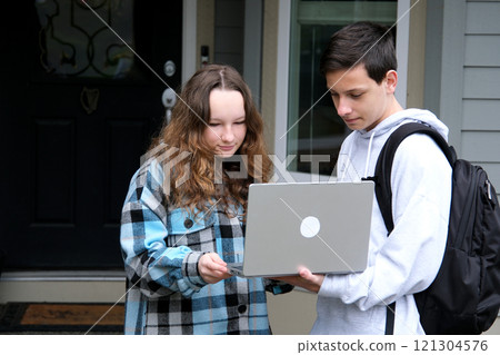 Happy young multiethnic couple spending time together at the park, studying while sitting at the table with laptop Happy young multiethnic couple spending time together at the park, studying while sitting at the table with laptop 121304576