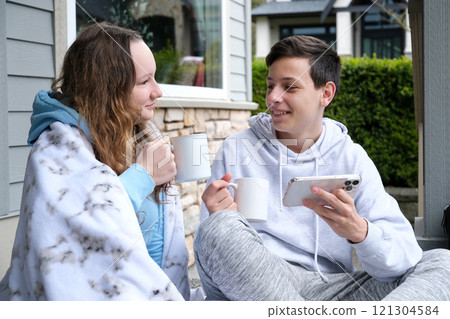 Laughing couple in love. Handsome man with beard and his elegant wife enjoying coffee break in cafe outdoor. Couple hugging and talking.  121304584