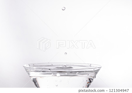 Close up of water drop falling into a glass on white background	 121304947