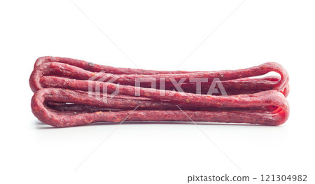 Smoked kabanos. Mini dried thin sausages isolated on white background Smoked kabanos. Mini dried thin sausages isolated on white background 121304982