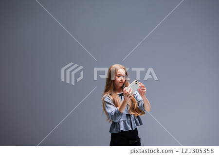 A Young Girl Holding a Brightly Colored Paper Star in an Inspiring Creative Studio Setting A Young Girl Holding a Brightly Colored Paper Star in an Inspiring Creative Studio Setting 121305358