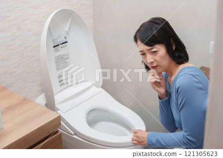 Middle-aged woman suffering from toilet trouble Middle-aged woman suffering from toilet trouble 121305623