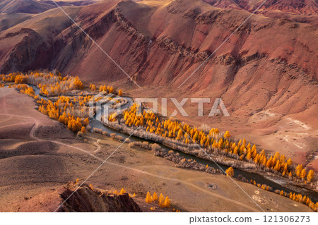 Aerial View of Autumn River Through Vibrant Red Hills in Mountain Valley 121306273