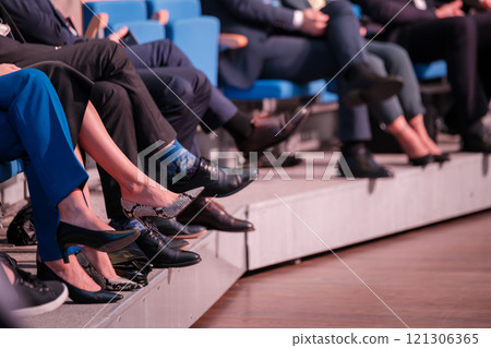 Attendees seated in rows wearing formal attire during a professional event 121306365