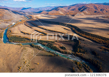 Aerial view of a winding river flowing through vast autumnal landscapes 121306378