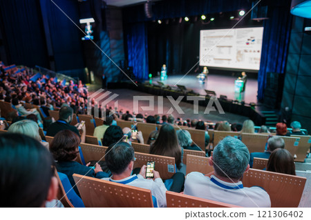 Large audience attending a presentation in a modern auditorium Large audience attending a presentation in a modern auditorium 121306402