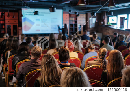 Audience attending a presentation in a modern conference room setting 121306428