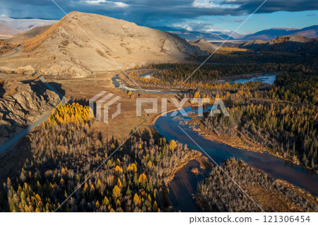 Aerial view of serene autumn landscape in Altai region with winding river 121306454