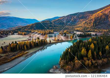 Mountain valley with river reflecting vibrant autumn forest under clear sky 121306464