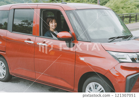 一名年輕女子駕駛自己的汽車 121307051