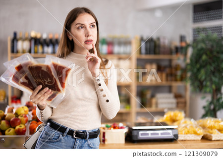 Young woman choosing jamon in grocery store Young woman choosing jamon in grocery store 121309079