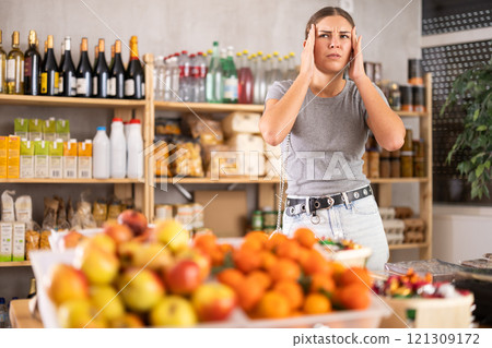 Female shopper suffers from headache while shopping at supermarket 121309172