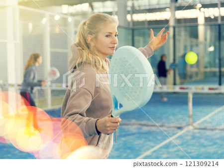 Woman playing padel in court Woman playing padel in court 121309214
