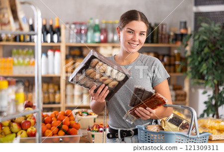 Young woman choosing sweets in supermarket 121309311