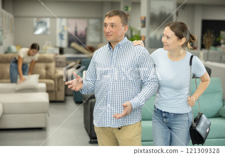 Happy married couple choosing furniture for home in shop Happy married couple choosing furniture for home in shop 121309328