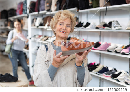 Portrait of a mature woman holding sports sneakers Portrait of a mature woman holding sports sneakers 121309329