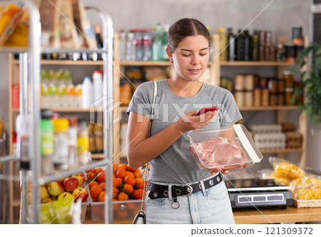 Woman holding phone and pork slices 121309372