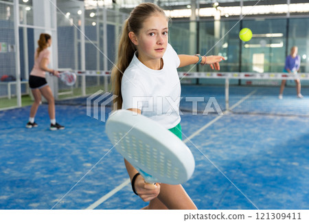 Girl tennis player playing padel tennis Girl tennis player playing padel tennis 121309411