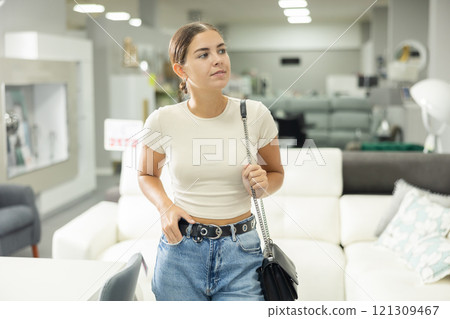 Girls eyes scan room furniture store, searching for perfect item to complete living space Girls eyes scan room furniture store, searching for perfect item to complete living space 121309467