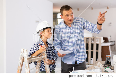 Man showing son blueprints in new home Man showing son blueprints in new home 121309589