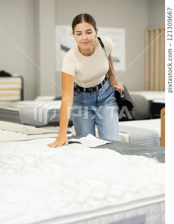 Woman in furniture center chooses best sofa for her apartment Woman in furniture center chooses best sofa for her apartment 121309667