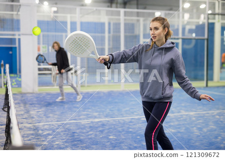 Portrait of a young woman playing padel 121309672