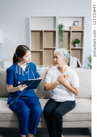 Asian caregiver doctor examine older patient use blood pressure gauge. woman therapist nurse at nursing home taking care of senior elderly Asian caregiver doctor examine older patient use blood pressure gauge. woman therapist nurse at nursing home taking care of senior elderly 121310647