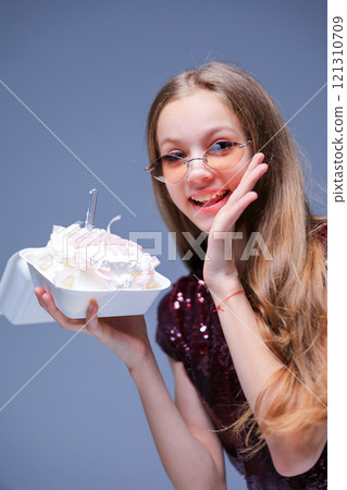 A cheerful girl joyfully celebrating her special day with a beautifully decorated birthday cake A cheerful girl joyfully celebrating her special day with a beautifully decorated birthday cake 121310709