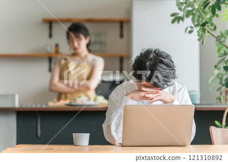 擔心使用電腦、遠距辦公、在家遠距工作的男人和做飯的女人(情侶) 擔心使用電腦、遠距辦公、在家遠距工作的男人和做飯的女人(情侶) 121310892