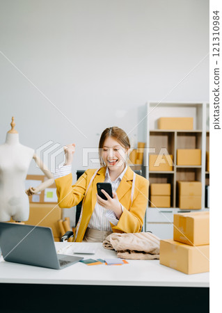 Startup small business SME, Entrepreneur owner woman using smartphone or tablet taking receive and checking online purchase shopping order Startup small business SME, Entrepreneur owner woman using smartphone or tablet taking receive and checking online purchase shopping order 121310984