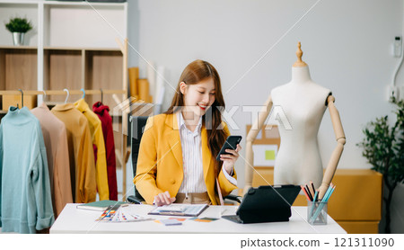 Asian tailor woman working on clothes in tailoring atelier. beautiful young female fashion designer smile 121311090