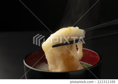 Picking up the mochi in ozoni with chopsticks 121311189