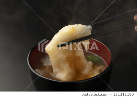 Picking up the mochi in ozoni with chopsticks 121311190