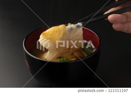 Picking up the mochi in ozoni with chopsticks 121311197