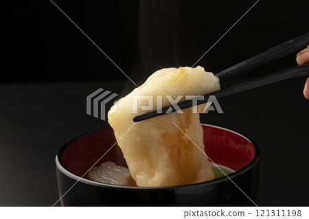 Picking up the mochi in ozoni with chopsticks 121311198