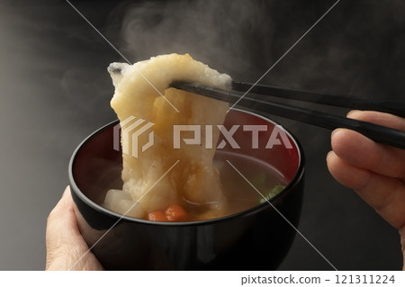 將碗放在手中，然後用筷子夾起麻糬。 121311224