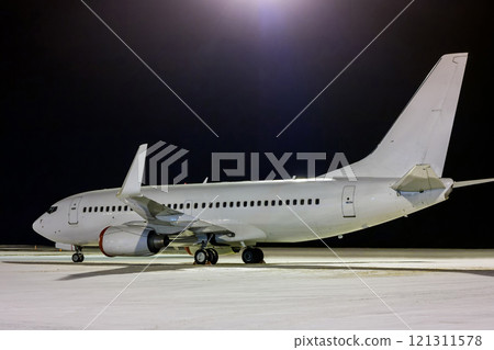 White passenger aircraft on the night airport apron at winter White passenger aircraft on the night airport apron at winter 121311578