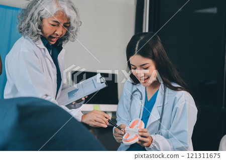 A team of doctors and nurses are working to treat a female patient in the patient's room. A team of doctors and nurses are working to treat a female patient in the patient's room. 121311675