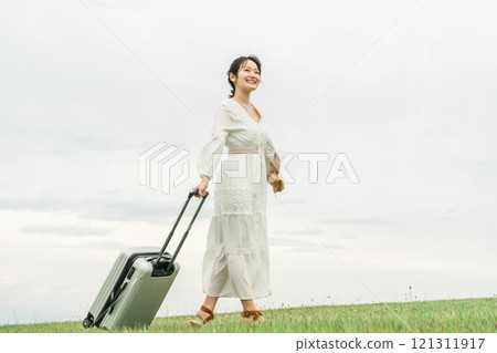 一位年輕的亞洲女性帶著手提箱旅行(夏季、度假村、假期) 一位年輕的亞洲女性帶著手提箱旅行(夏季、度假村、假期) 121311917