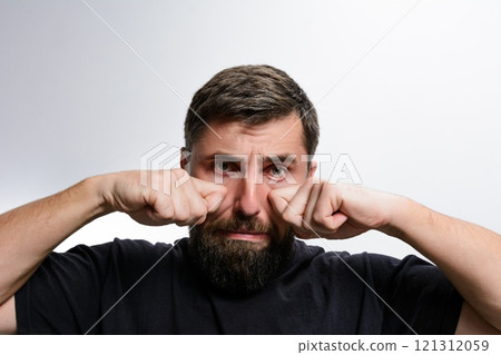Man with beard rubbing his eyes Man with beard rubbing his eyes 121312059