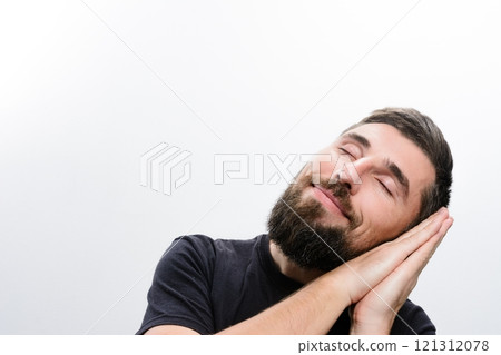 Man sleeping peacefully with hands together 121312078