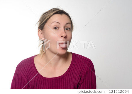 Woman sticking out tongue, playful expression. 121312094
