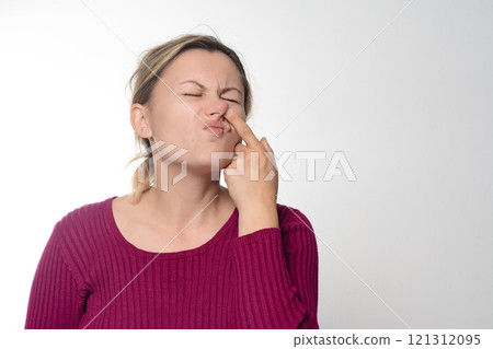 Woman picking her nose with a disgusted expression. 121312095