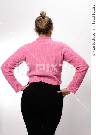 Woman in pink sweater and black leggings, back view. 121312122