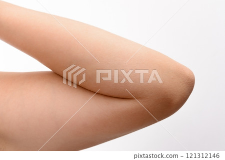 Close-up of a bent arm showing the elbow joint against a white background. 121312146
